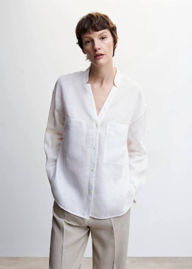 Camisa de lino con cuello de tira, escote de pico, manga larga, bolsillos y cierre de botones, color blanco, de Mango. Está disponible a 59,99 euros.