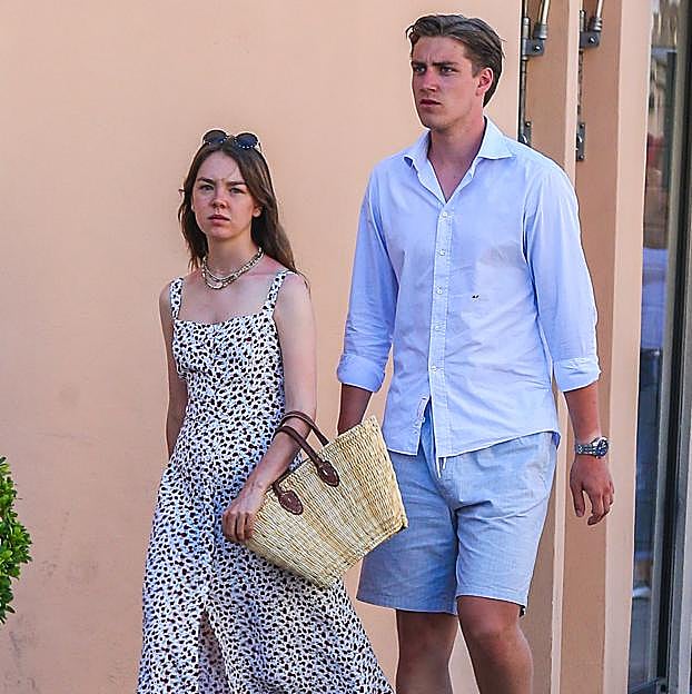 Alexandra de Hannover con su pareja y un look don vestido estampado y bolso de rafia.