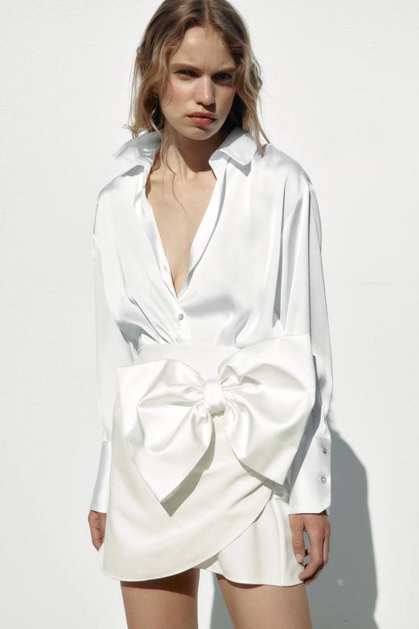 Falda pantalón en tejido satinado con tiro alto, diseño cruzado y detalle de maxi lazo delantero, en blanco, de Zara. Su precio es de 29,95 euros.