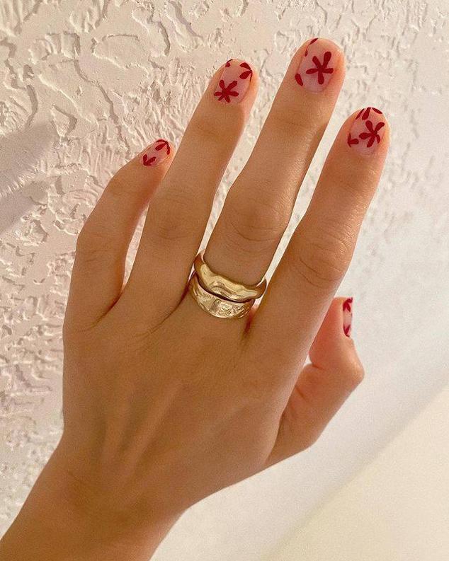 Sobre una base de esmalte en tono natural, haz dibujos de flores rojas en varias o todas tus uñas.
