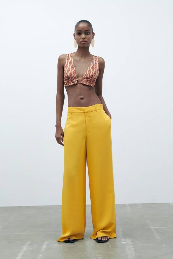 Pantalón pijamero fluido con perneras anchas, tiro medio, cintura elástica y bolsillos, tono amarillo, de Zara. Hazte con él a 39,95 euros.