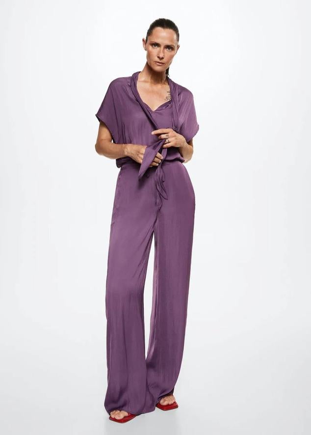 Pantalón ancho satinado con corte fluido, tiro alto, cintura elástica ajustable y bolsillos, en morado, de Mango. Consíguelo por 29,99 euros.