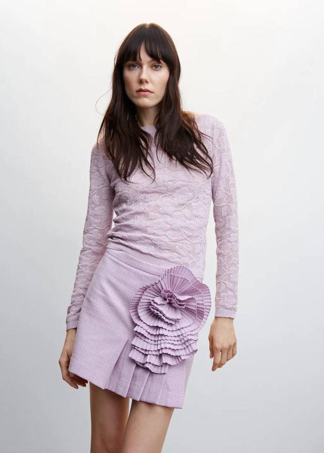 Falda corta con diseño de tablas y detalle de flor en relieve, color lila, de Mango. Su precio es de 45,99 euros.