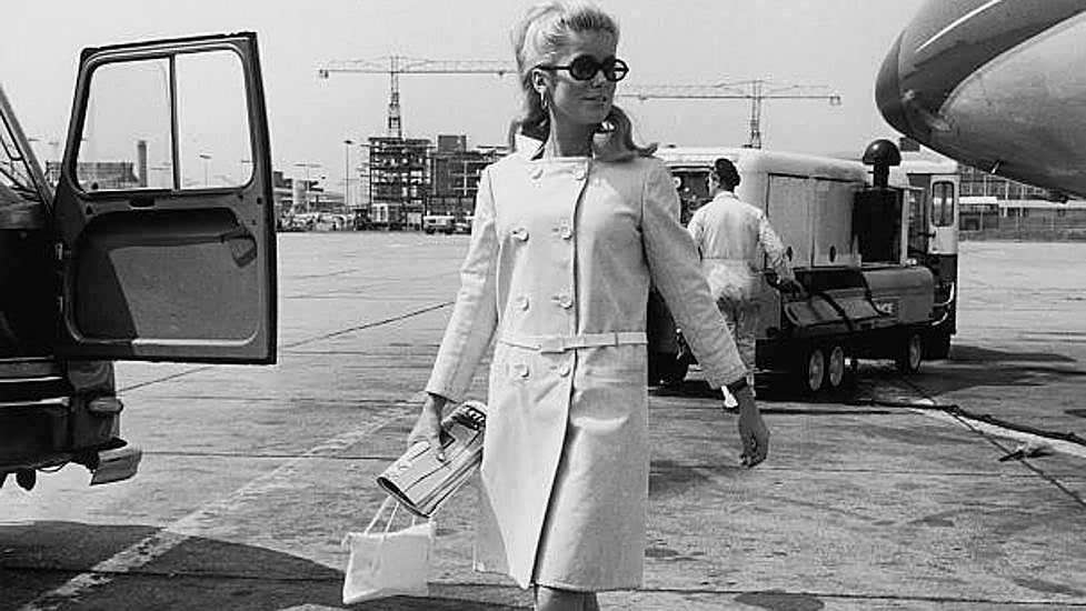 Catherine Deneuve, con abrigo de Courrèges, en el aeropuerto de Londres en 1965.