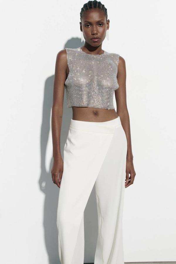 Pantalón pareo de vestir tipo fluido con diseño cruzado y perneras anchas, color blanco, de Zara. Hazte con él por 29,95 euros.