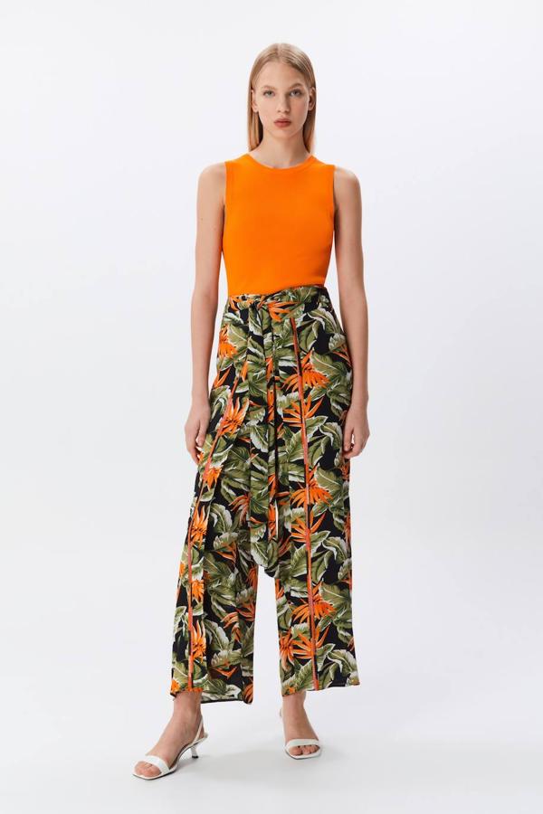 Pantalón pareo con pieza de tejido superpuesta, corte fluido, tiro alto y lazada, en print tropical, de Sfera. Puedes comprarlo por 29,99 euros.