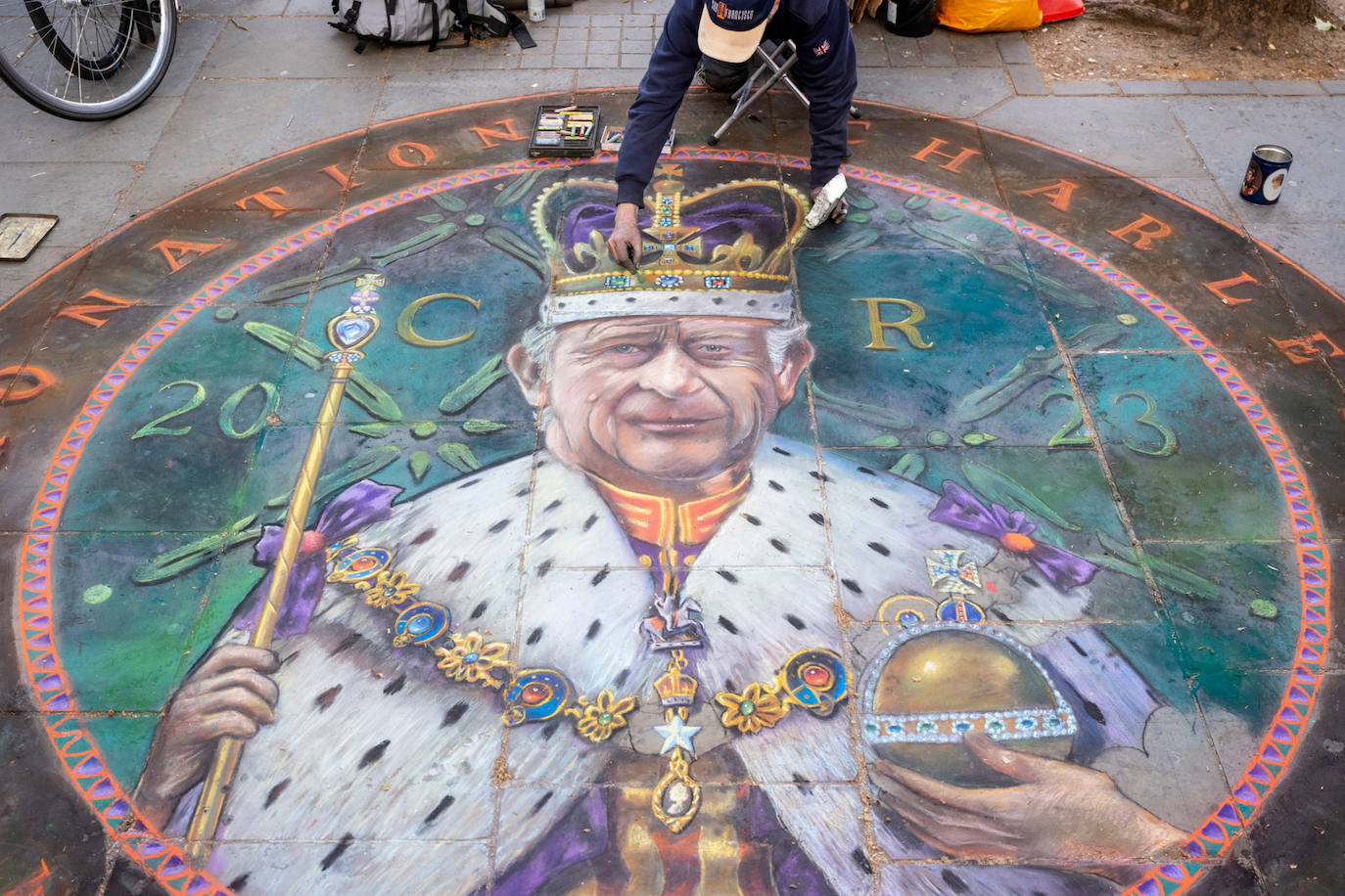 Pintura ggiante en el suelo de Trafalgar Square con la imagen de Carlos III con la corona, el cetro y la orbe.