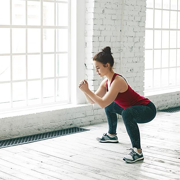 Mujer realizando una sentadilla. 