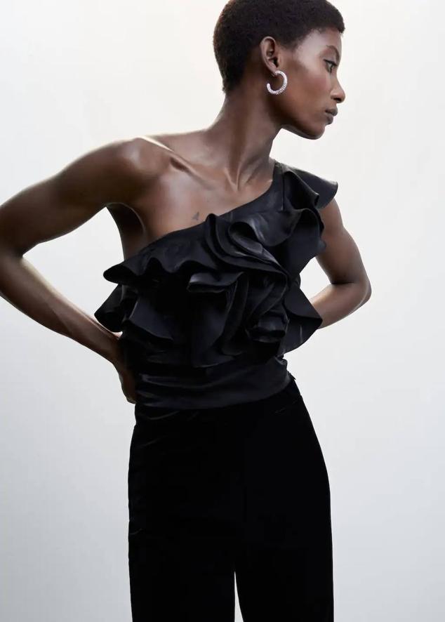 Top con escote asimétrico, un tirante ancho y adornos de volantes, color negro, de Mango. Lo encontrarás por 39,99 euros.