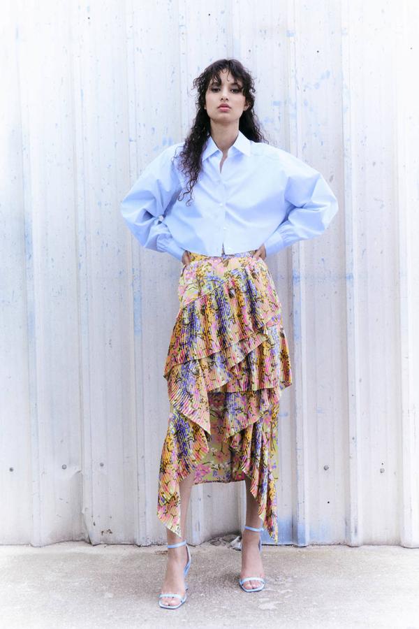Falda midi con volantes plisados, tiro alto y bajo asimétrico, en floral print multicolor, de Sfera. La encontrarás a 39,99 euros.