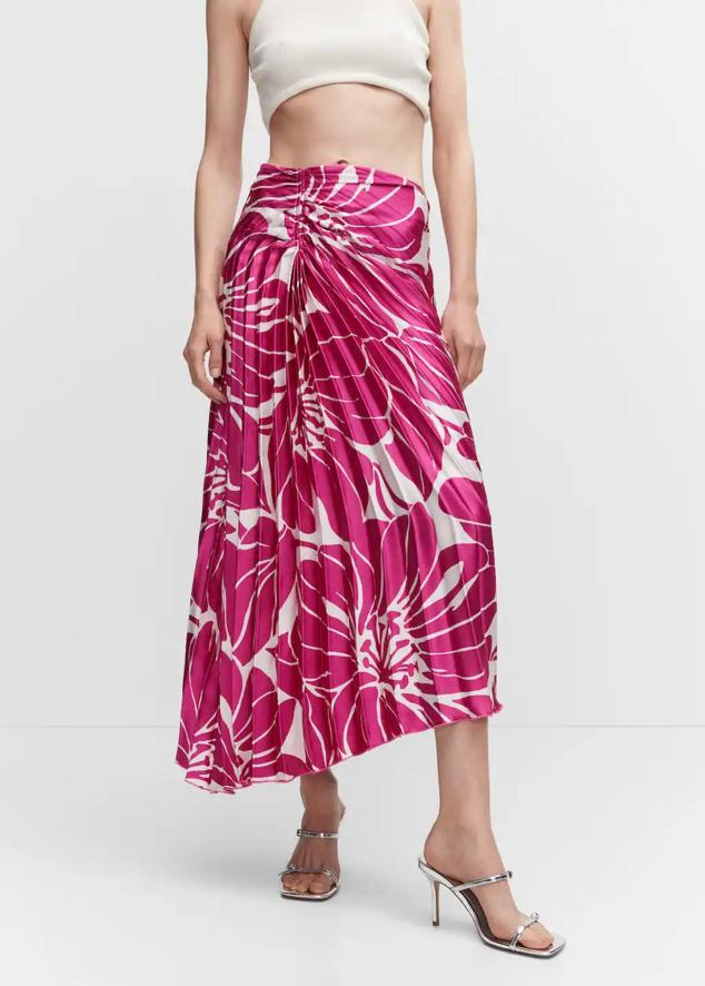 Falda midi asimétrico con tiro alto y diseño plisado, en floral print rosa fucsia, de Mango. Cuesta 39,99 euros.