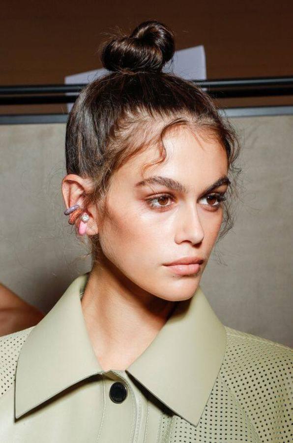 Un peinado que puede parecer muy flamenco o rejuvenecedor. Solo tienes que hacer un moño alto tirante. Y, para conseguir el efecto baby hairs, le damos forma a los pelos sueltos pequeños que están en la línea de nacimiento del pelo, bien ondulándolos o fijándolos a la cara con gel y laca.