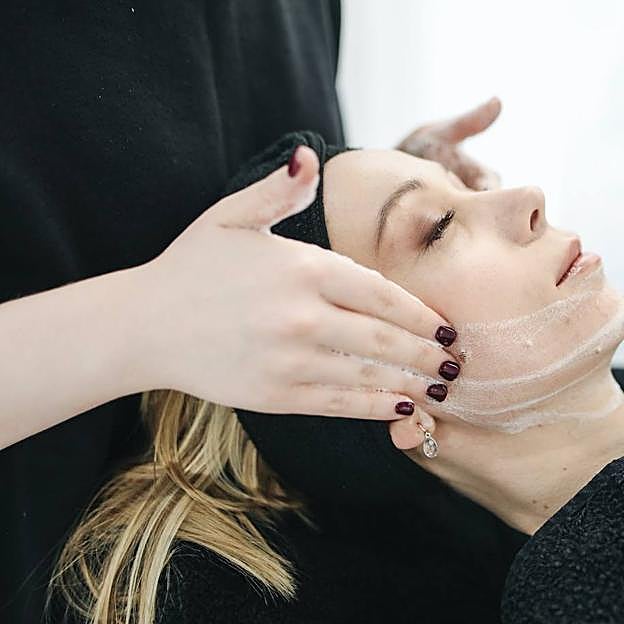 Facialista aplicando una limpieza facial profunda