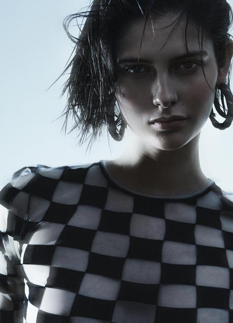 Imagen - La modelo posa con camiseta de estampado damero y pendientes en forma de aro.