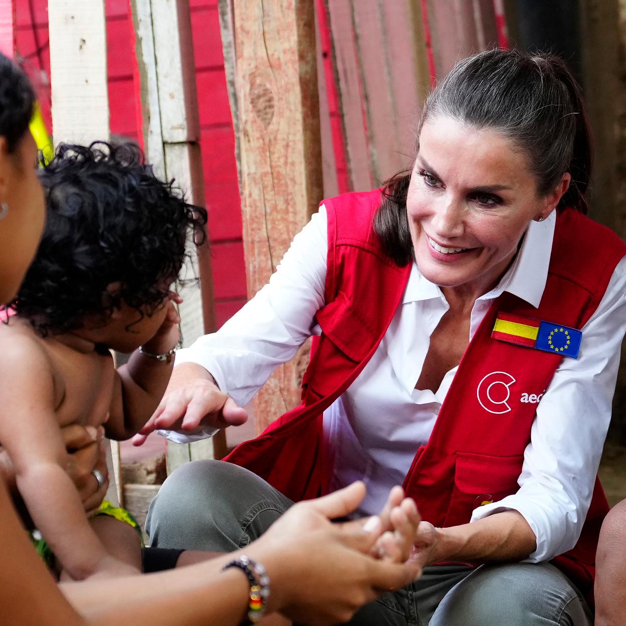 La reina Letizia saluda a un bebé durante el viaje a Colombia.