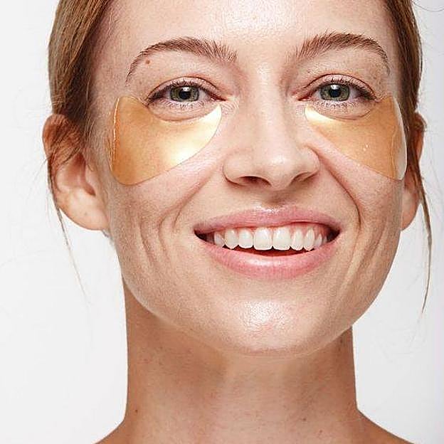 Mujer con mascarilla de ojos para eliminar patas de gallo