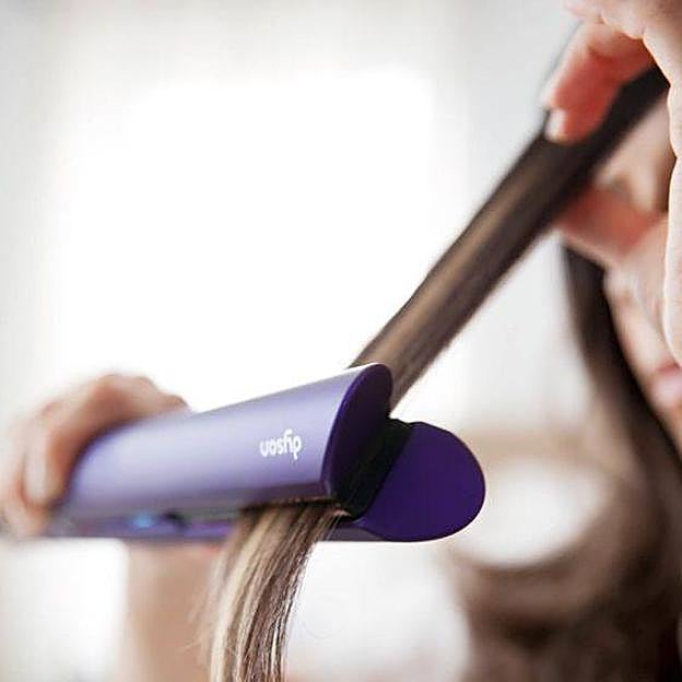 Mujer usando plancha de pelo profesional