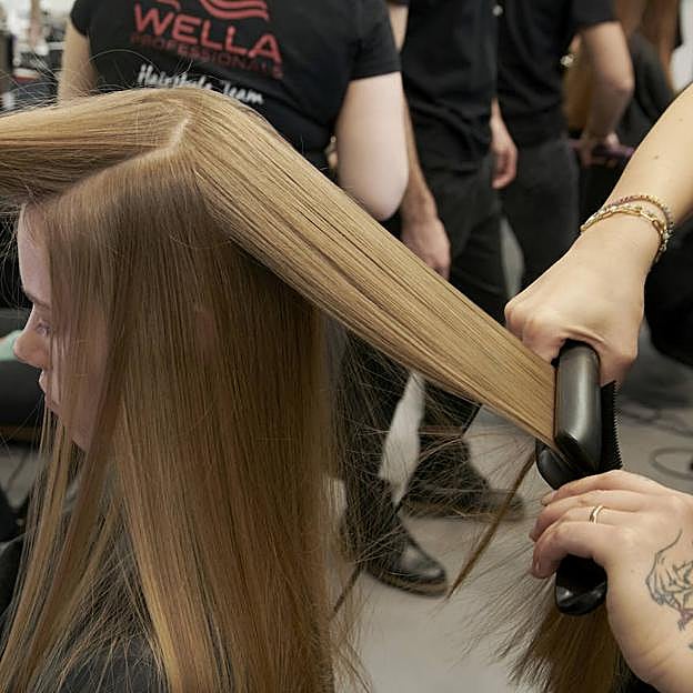 Profesional realizando técnica para planchar el pelo