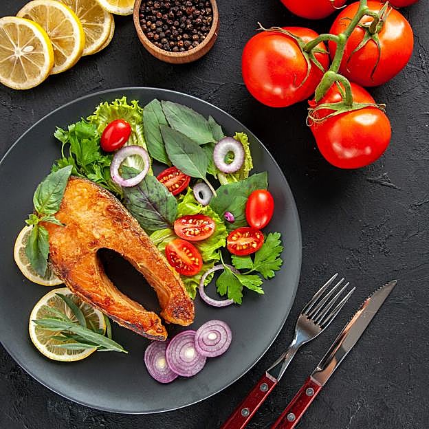 Plato con un filete de salmón a la plancha con ensalada fresca. 