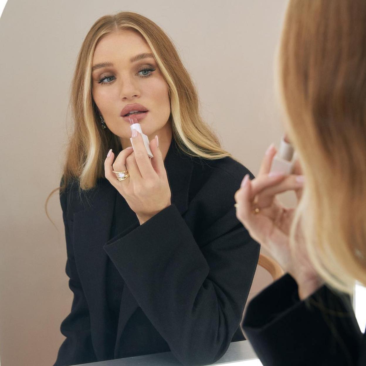 La modelo Rosie Huntington-Whiteley pintándose los labios.