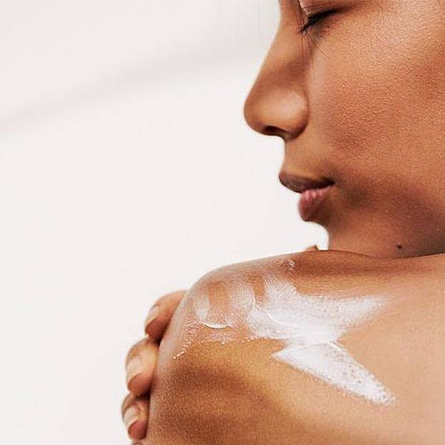 Mujer aplicando crema para piel atópica