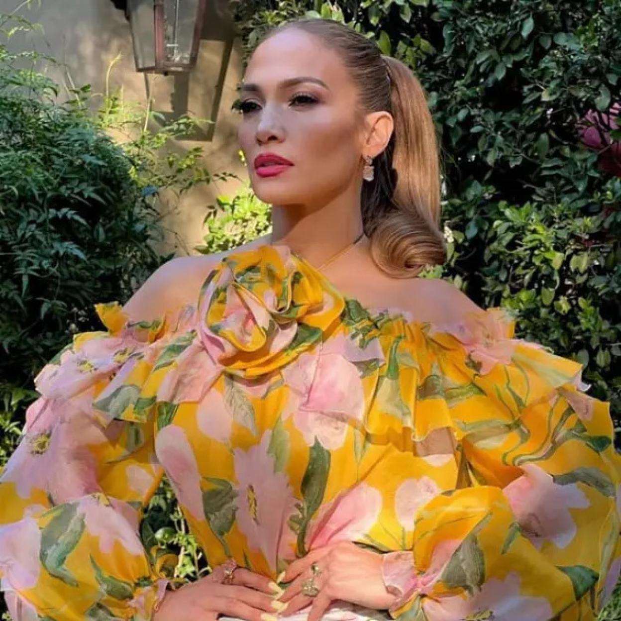Jennifer Lopez con una blusa amarilla de flores.