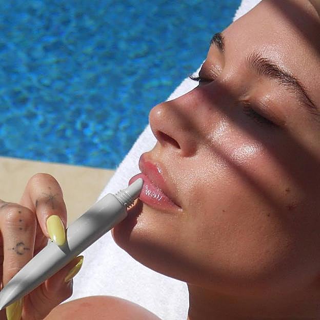 Hailey Bieber aplicando un bálsamo en los labios