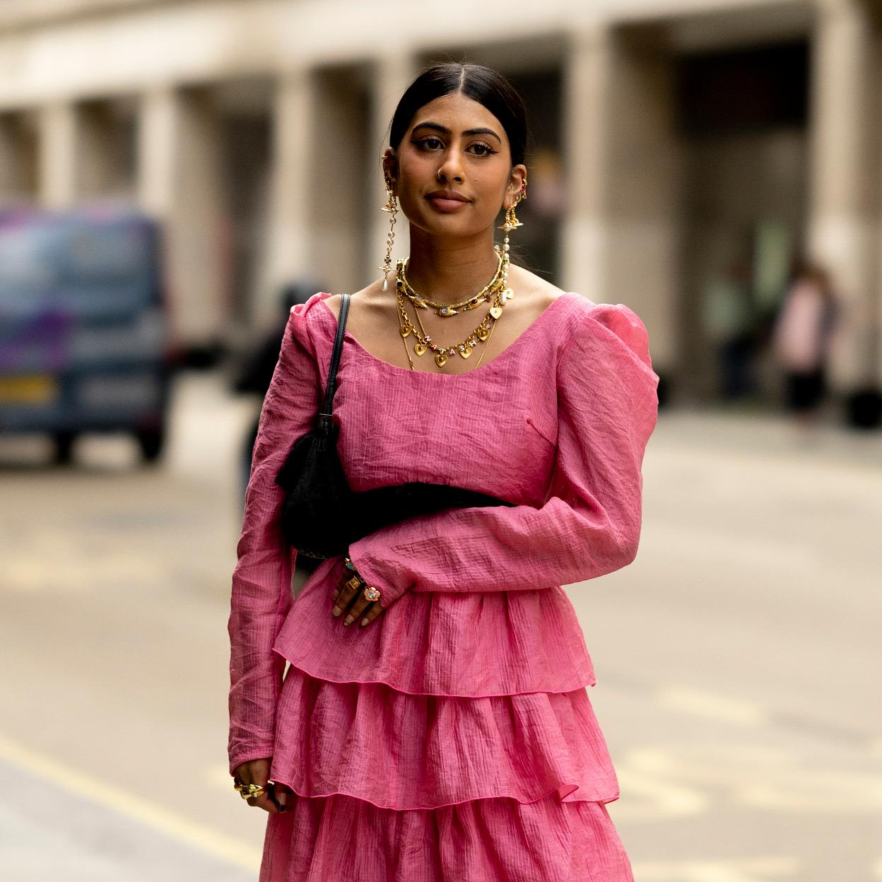 Una mujer con pendientes largo y collares.
