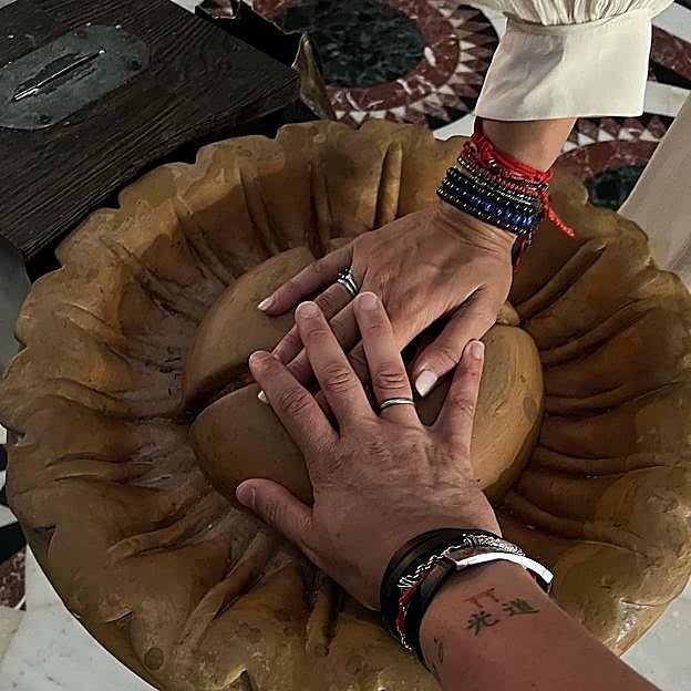 Las manos entrelazadas de los presentadores mostrando sus anillos 