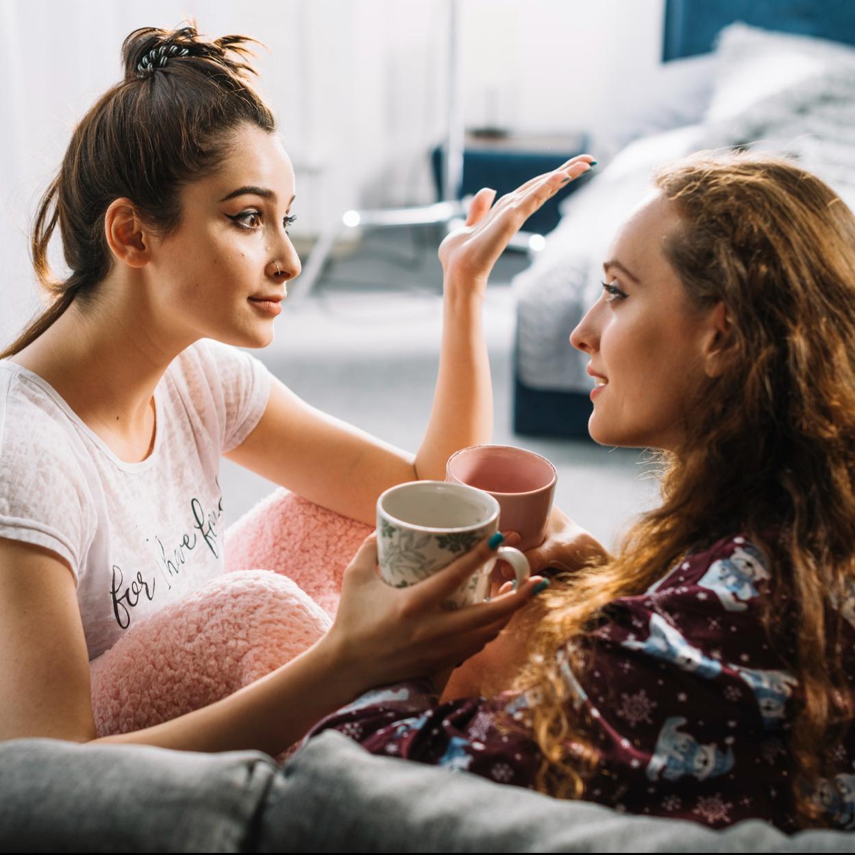 Dos amigas conversando mientras toman un café. 