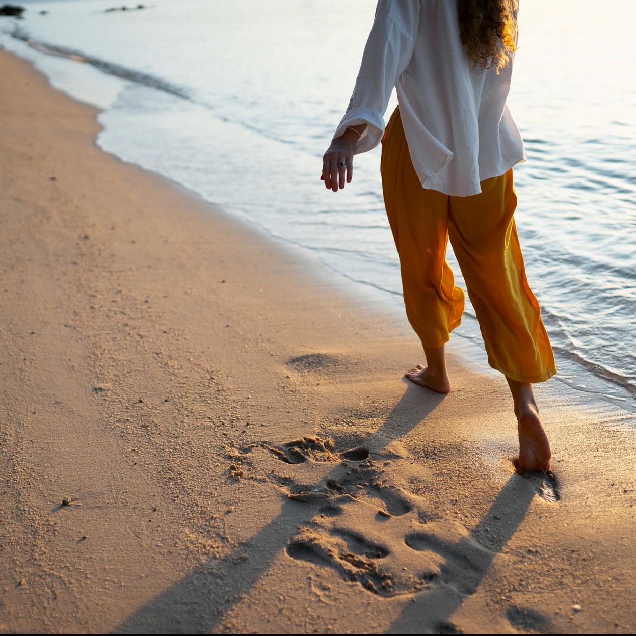 Mujer caminando en la orilla del mar. 