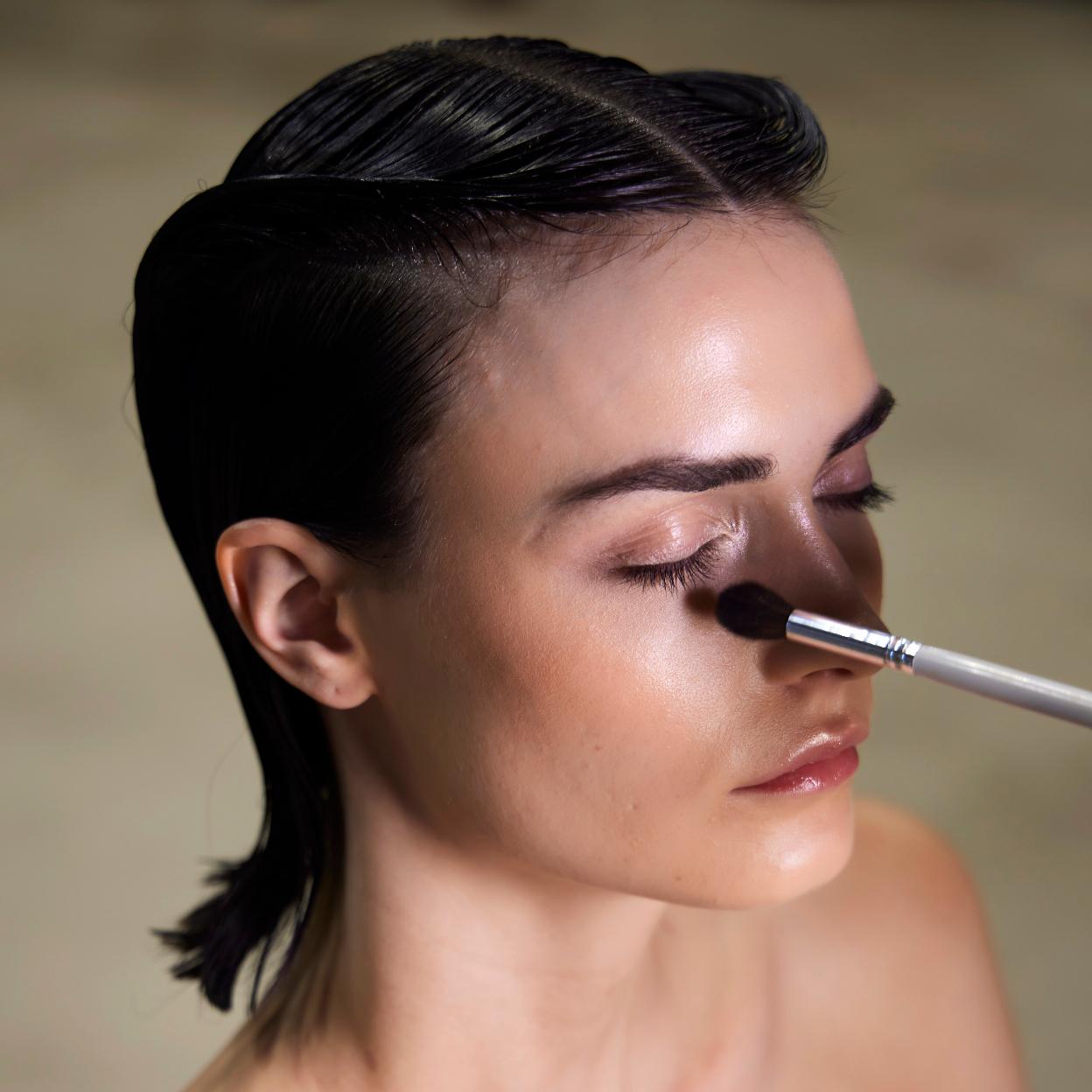 Aplicando un corrector de ojeras a una modelo.