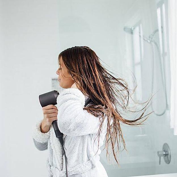 Mujer usando secador en el pelo
