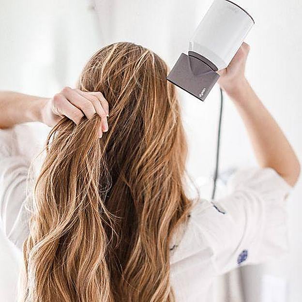 Mujer utilizando secador de pelo de forma correcta