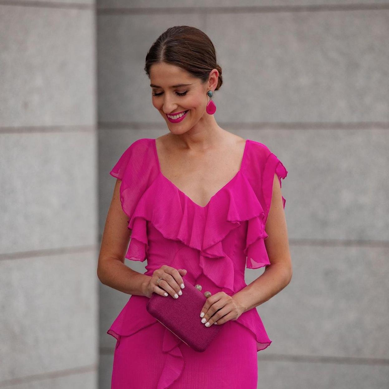 Una mujer con vestido fucsia.