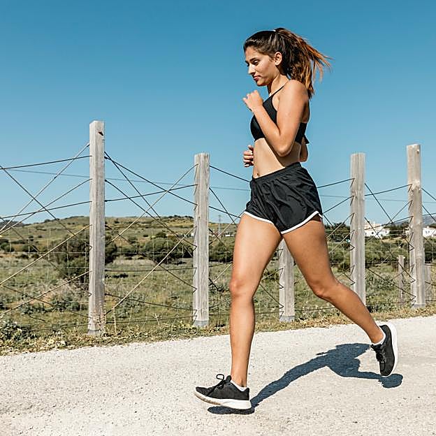 Mujer andando rápido por un camino. 