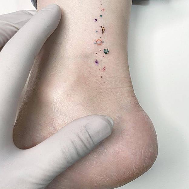 Tatuaje en el tobillo con estrellas y planetas