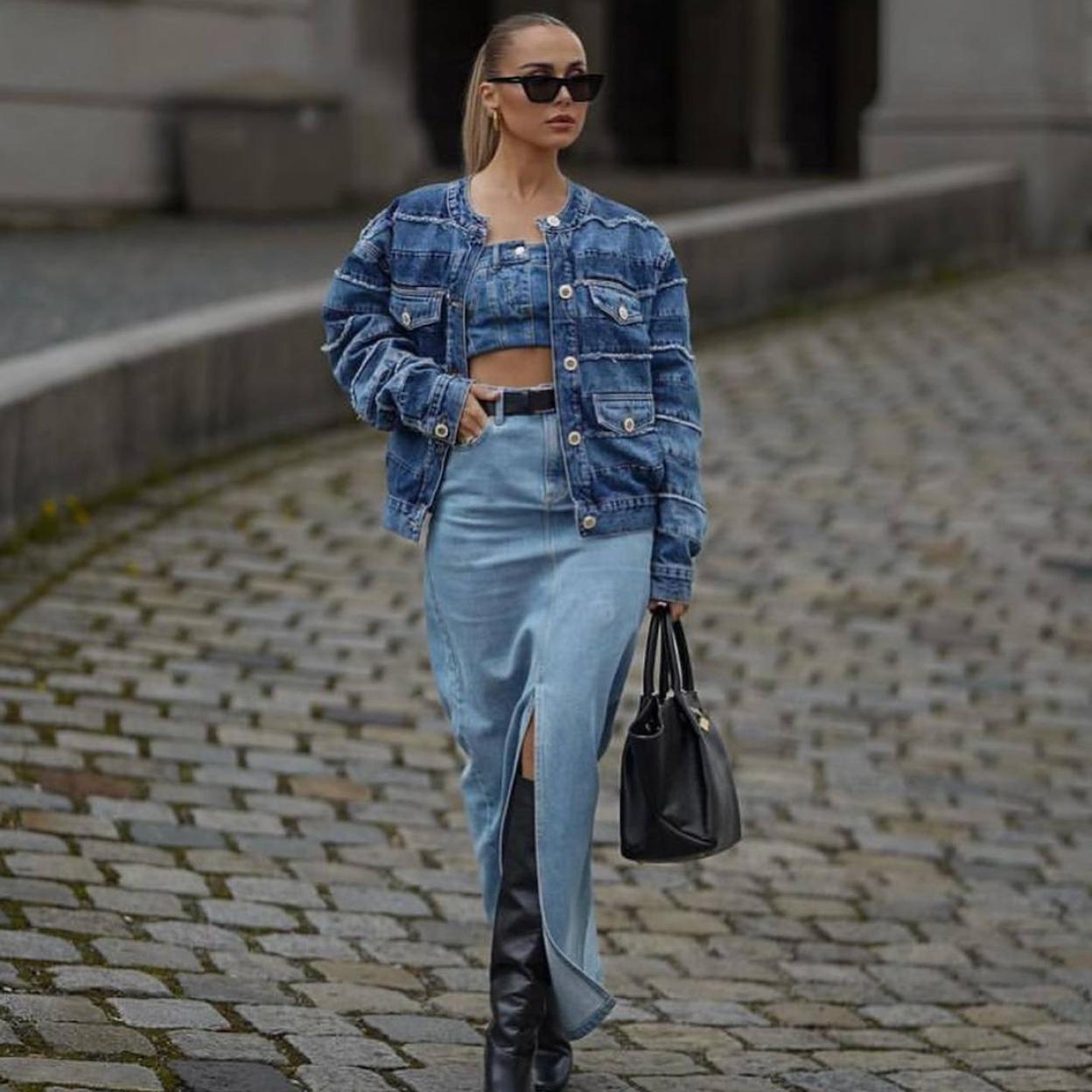 La influencer lleva un look con falda vaquera midi y botas altas