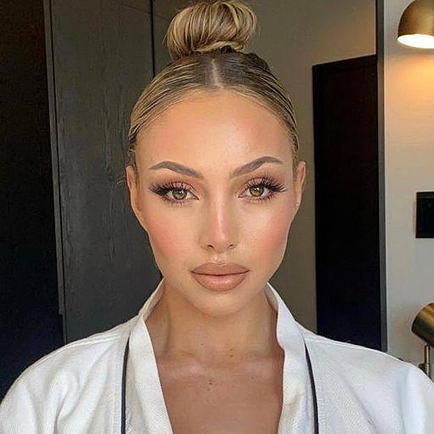 Mujer con mirada luminosa por uso de corrector de ojeras rosa