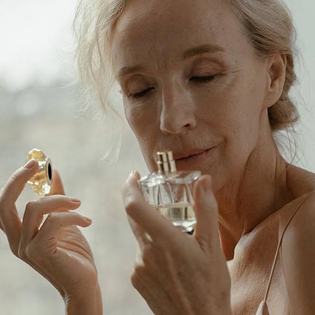 Mujer oliendo un perfume nicho