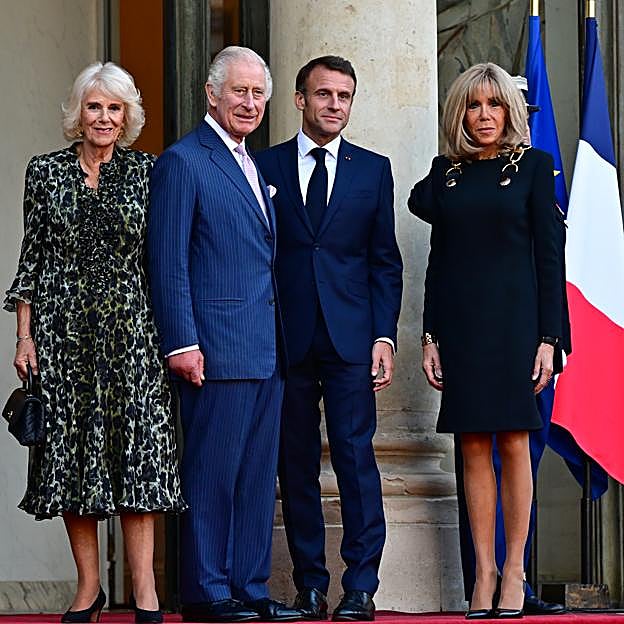 El 'petit robe noir' de Brigitte Macron frente al vestido camisero de la reina Camilla, representa a la perfección las diferencias de estilo a los 70 años de ambas. 