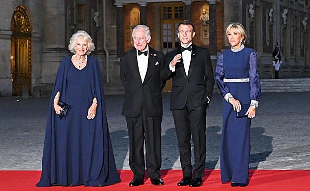 En la cena de gala en el Palacio de Versalles, la reina británica y la primera dama francesa coincidieron solo en el color de sus vestidos, azul noche. 