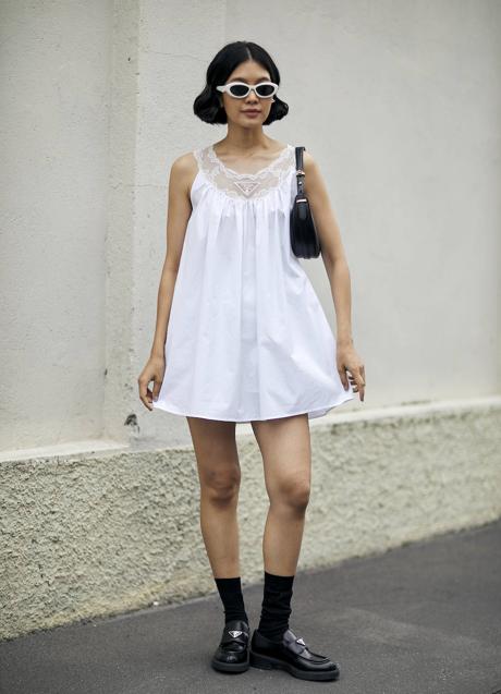Imagen - Asistente al desfile de Prada en Milán combina mocasines y calcetines negros, con minivestido blanco.