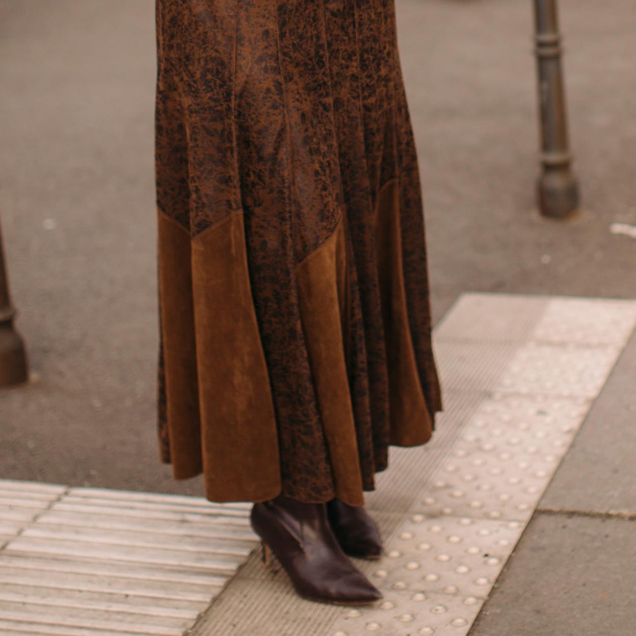 Una mujer con botines en marrón chocolate.