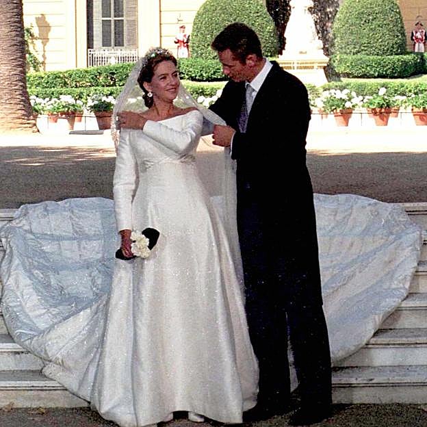 Iñaki Urdangarin ayuda a la infanta Cristina a colocarse el manto propiedad de la reina María Cristina de Habsburgo y restaurado por los profesionales del Museo del Traje.