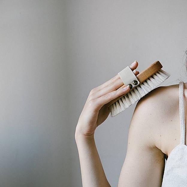 Mujer usando cepillo exfoliante