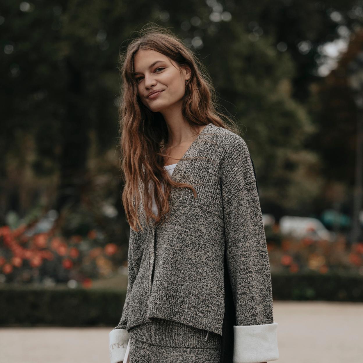 Una mujer con prendas de punto en gris.