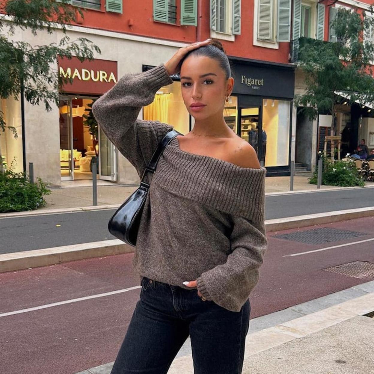 Una mujer con jersey escote bardot de Pull & Bear.