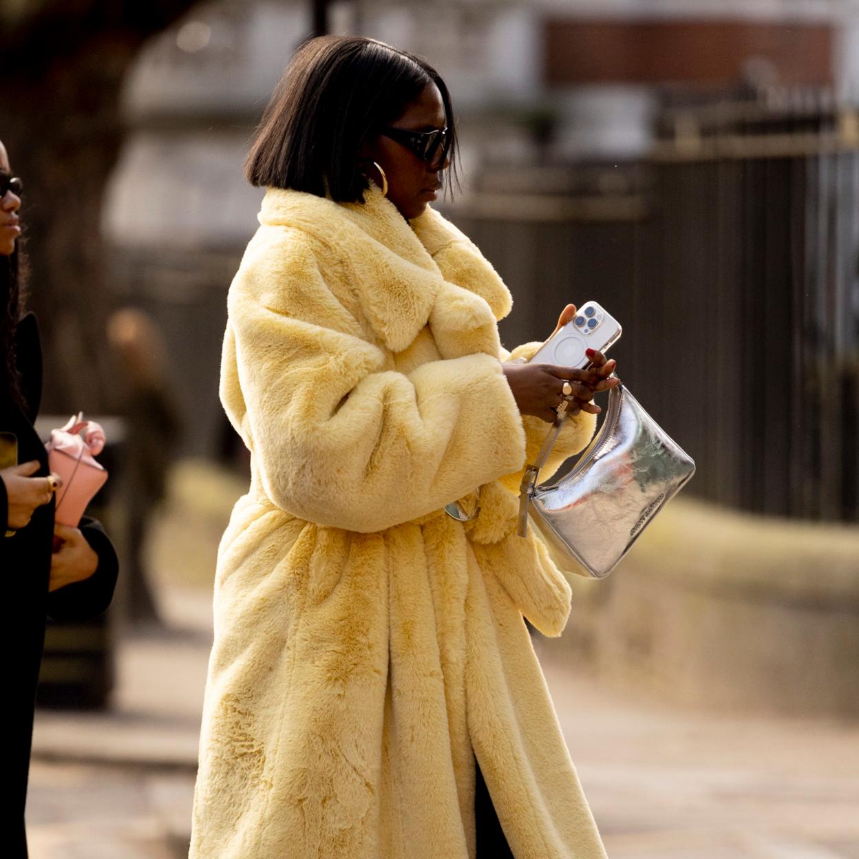 Una mujer con bolso plateado.