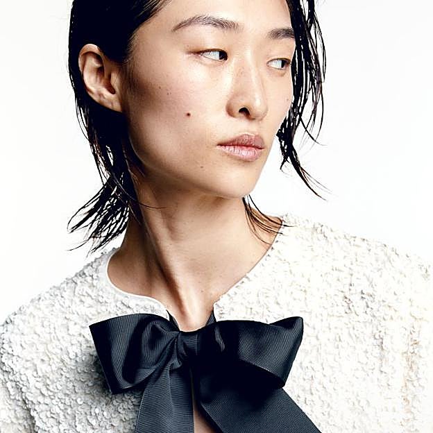 Imagen principal - Chaqueta de lentejuelas en blanco con lazos negros de H&M (39,99 euros).